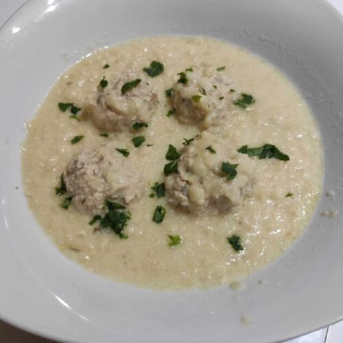 Traditional Greek Giouvarlakia with Chicken and Trahana soup served warm in a rustic bowl