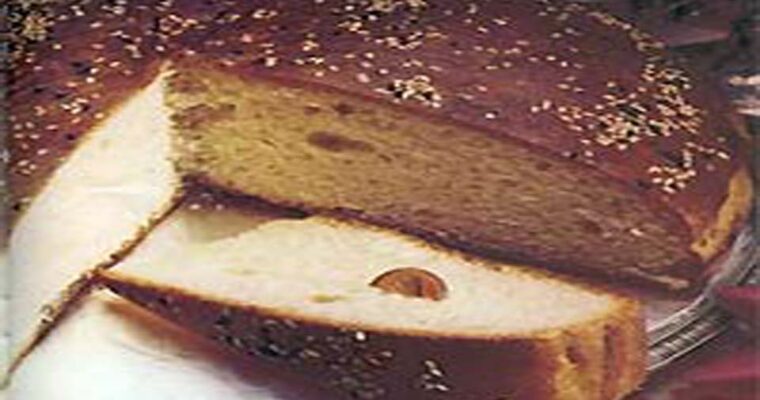 A beautifully Greek Vasilopit, almond slices, with a gold coin symbolizing the New Year tradition, set in a festive holiday ambiance.