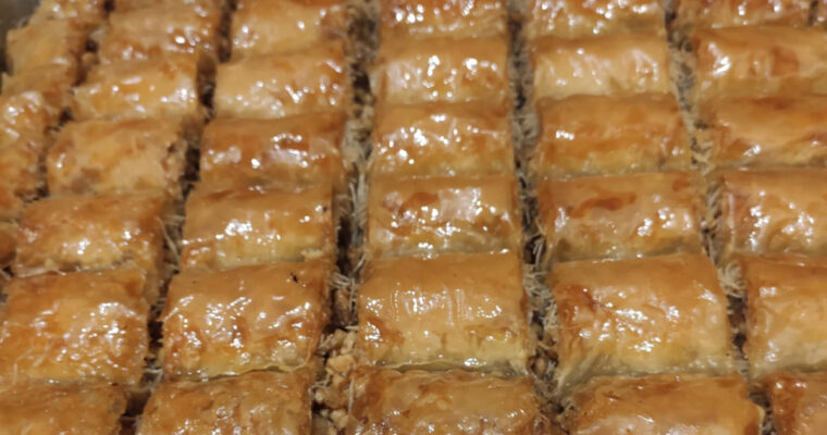 Greek Gianniotiko rolls made with phyllo and kataifi pastry, filled with walnuts, breadcrumbs, and soaked in syrup.
