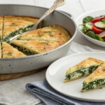 Traditional Vlachiki Spanakotyropita, a Greek spinach and cheese pie with homemade phyllo, baked to golden perfection in a rustic pan.